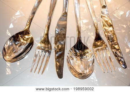 Fork, spoon and knife with reflections and light effects