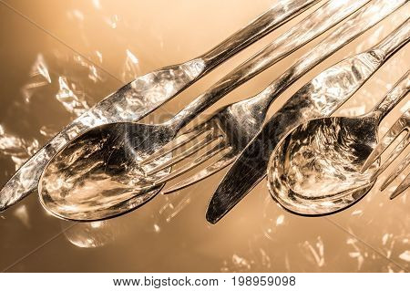 Fork, spoon and knife with reflections and light effects