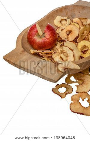 Dried apple rings lie on a board with a freshly cut apple