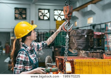 Factory Female Worker Adjusting Chain Cranes