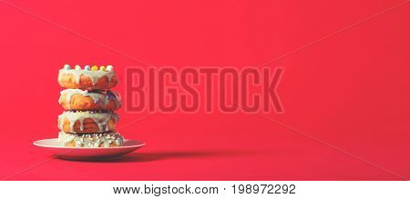 Colorful glazed donuts on a bright red background