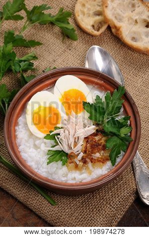 Rice porridge ginger congee with egg chicken crispy shallots and parsley