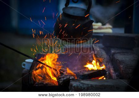 Boiling kettle on the fire in the evening