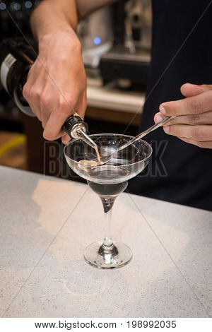 The barman at the bar prepares a delicious cocktail