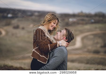 Beautiful Lovely Couple In The Park Or Field Or Track. Man In Coat And Scarf With Girl In Coat. Man 