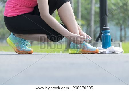 Exercise To Keep The Body Healthy,women Wear Pink Shirts And Black Pants Are Shrunk To Tie The Shoe,