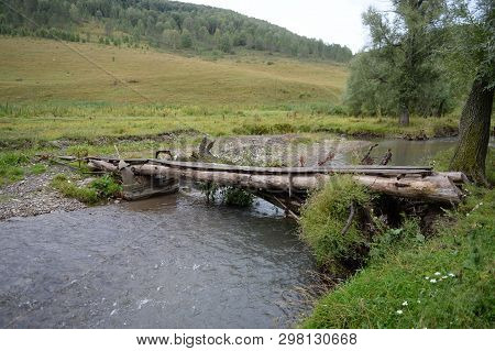 Homemade Bridge On The Mountain River Yarovka In The Taiga Settlement Of Generalka Of The Altai Terr