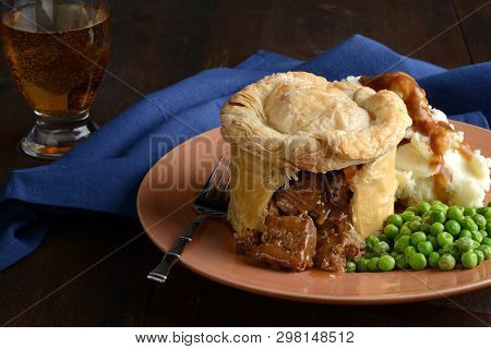 Cut Steak Pie With A Fork With Glass Of Beer