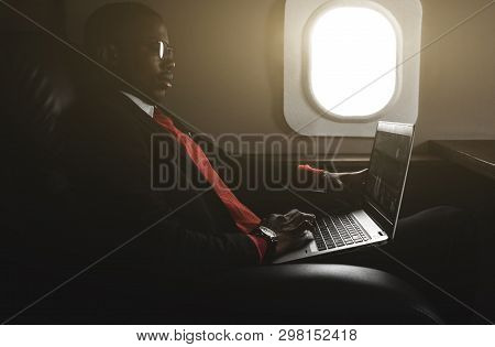 Attractive And Successful African American Businessman With Glasses Working On A Laptop While Sittin