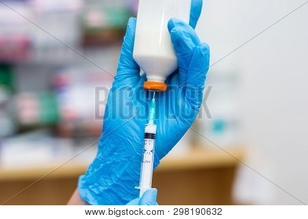 The Veterinarian Women With Blue Gloves Extract A White Drug With A Syringe