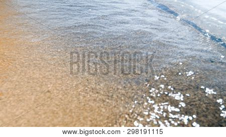 Blurred Photo Of Calm Sea On The Sandy Beach At Brught Sunny Day