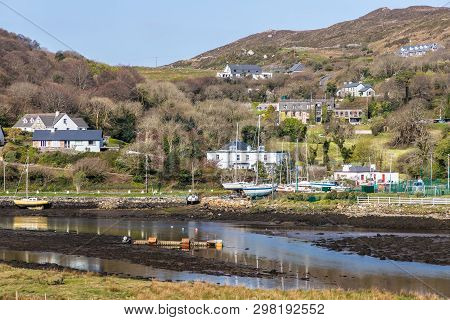 Pier With Buildings And Boat In A Low Tide Clifden Bay