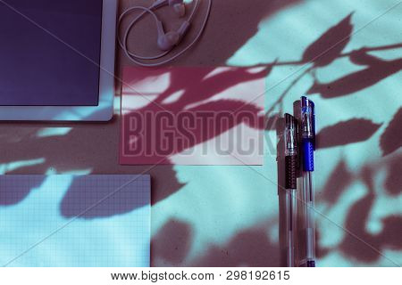 Work Office Space With A Tablet, Notebook, Pens And Headphones Top View, Flat Lay, Copy Space. Pink 