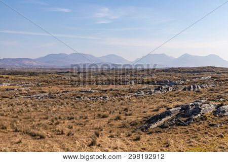 Rocks In A Bog With Twelve Bens Mountains In Background