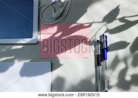 Work Office Space With A Tablet, Notebook, Pens And Headphones Top View, Flat Lay, Copy Space. Pink 