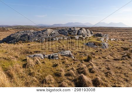 Rocks In A Bog With Twelve Bens Mountains In Background