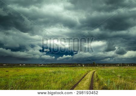 Dark Rain Storm Clouds Over The Field.
