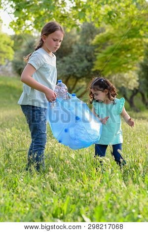 Children Volunteers With Garbage Bags Cleaning Up Rubish Outdoors.young Girls Collecting Garbage On 