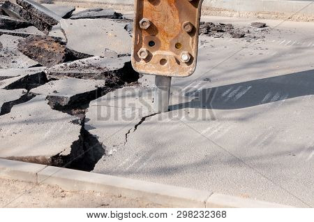 Machine Drills Asphalt. Large Fragments Of Land And Pits Everywhere On The Road. Working Equipment W