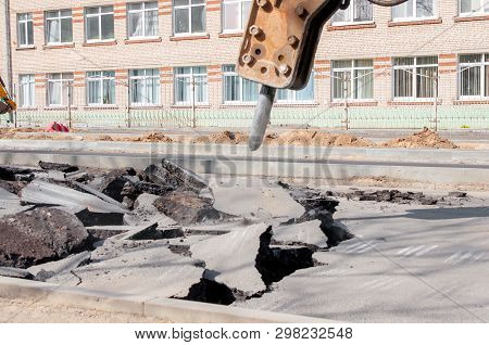 Machine Drills Asphalt. Large Fragments Of Land And Pits Everywhere On The Road. Working Equipment W
