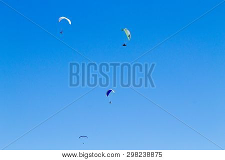 Paraglider On Blue Sky. Borso Del Grappa, Famous Paragliding Site, Italy