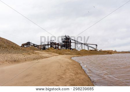 Stationary Rusty Separator Of Sand And Gravel On The Sandy Bank Of The River