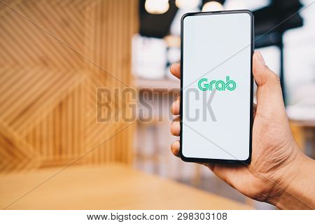 Chiang Mai, Thailand - Mar. 23,2019: Man Holding Xiaomi Mi Mix 3 With Grab Apps On Screen. Grab Is S