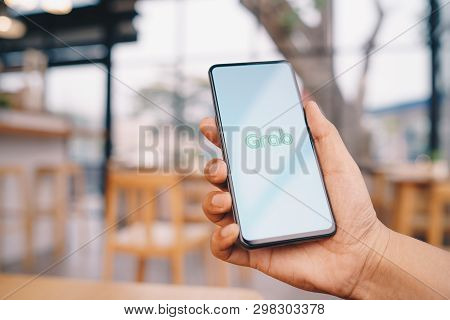 Chiang Mai, Thailand - Mar. 23,2019: Man Holding Xiaomi Mi Mix 3 With Grab Apps On Screen. Grab Is S