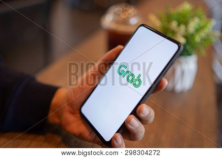 Chiang Mai, Thailand - Mar. 24,2019: Man Holding Xiaomi Mi Mix 3 With Grab Apps On Screen. Grab Is S
