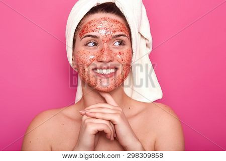 Smiling Sincere Female Looks Aside, Posing Isolated Over Pink Background In Studio, Being Naked, Try