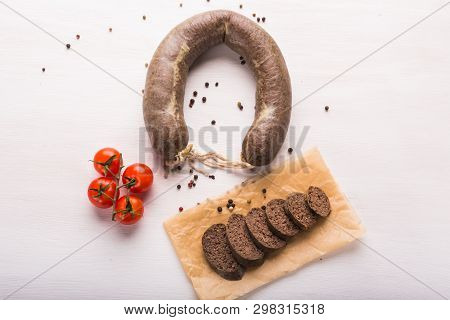 Food, Cuisine And Horsemeat Concept - Close Up Of Meat Sausage With Tomatoes And Pepper On Kraft Pap
