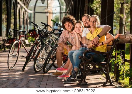 Happy Friends With Bicycles In Park. Cute Cheerful Group Of Friends Enjoying Summer Day In Park. Hap