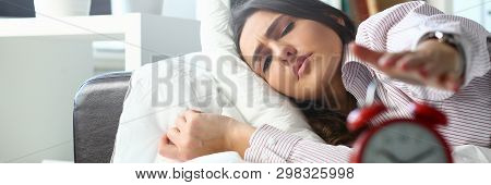 Sleepy Young Woman Portrait With One Opened Eye Trying Kill Alarm Clock. Early Wake Up Not Getting E