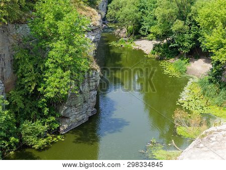 Calm River Flowing In Canyon With Overhanging Cliffs On Bank At Summer Day, View From Above. Buky Ca
