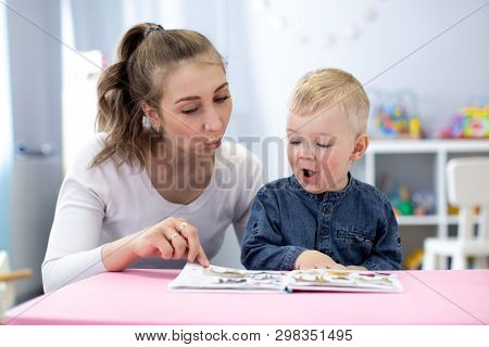 Speech Therapist Teaching Letter Pronunciation To Child Boy In Classroom