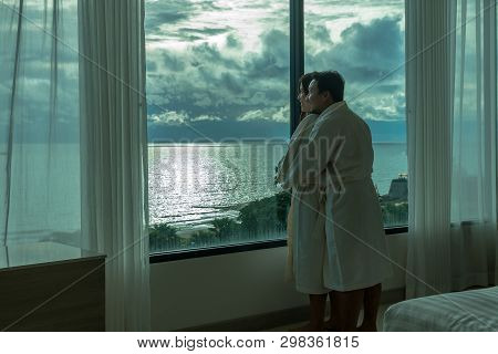 Asian Lovers In Bathrobe Suit Hugging And Sightseeing The Sea Beach When Waking Up From The Bed In L