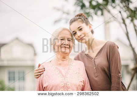 Happy Youg Caucasian Woman Hugging  Elderly Asian Woman Outdoor
