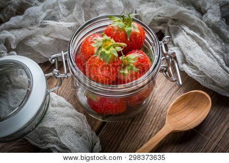 Strawberry In Jar On Wooden Background.