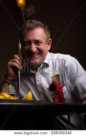 Fabulous At Any Age. Portrait Of Fashionable 50-year-old Man In Stylish Siut Posing At Restaurant. T