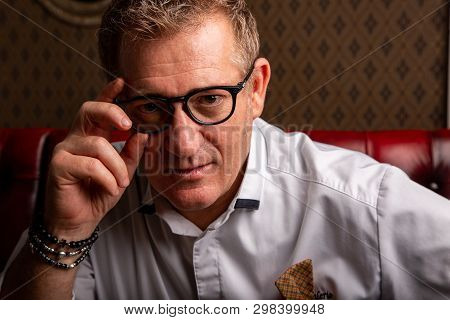 Fabulous At Any Age. Portrait Of Fashionable 50-year-old Man In Stylish Siut Posing At Restaurant. T