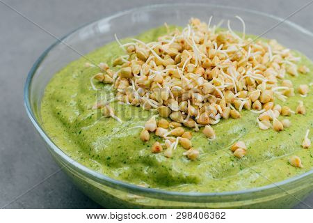 Close Up Shot Of Homemade Spinach Smoothie In Bowl Covered With Buckwheat Sprouts. Vegan Smoothie. O