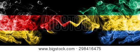 Germany Vs Gabon, Gabonese Smoky Mystic Flags Placed Side By Side. Thick Colored Silky Smoke Flags O