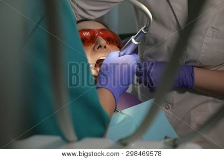 Dentist Is Taking Care About Patients Tooth With Black Cavity On It Using Electric Dental Brush. Nur