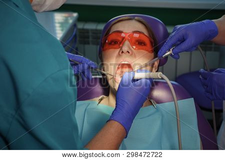 Dentist Is Taking Care About Patients Tooth With Black Cavity On It Using Electric Dental Brush. Nur