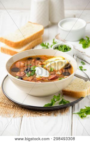 Traditional Russian Soup Solyanka With Beef, Chicken, Sausage, Lemon, Olives And Pickled Cucumber. D