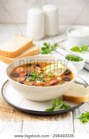 Traditional Russian Soup Solyanka With Beef, Chicken, Sausage, Lemon, Olives And Pickled Cucumber. D