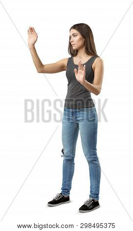 Fit Beautiful Woman In Gray Top And Blue Jeans Standing In Half-turn Posing With Hands Raised As If 