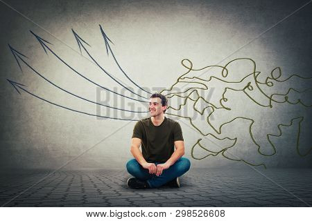 Cheerful Relaxed Young Man Seated On The Floor Happy Emotion. Concept Of Information Processing As M