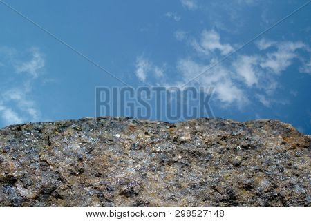 Rock Or Stone On Blue Sky With Clouds Background. Granite Crouan Rim Or Pick Edge Like Cliff Or Moun