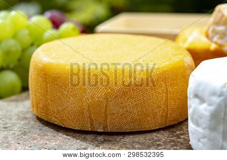 French Cheeses Collection, Yellow  Le Peche Des Bons Peres Cheese Served With Grapes On Marble Plate